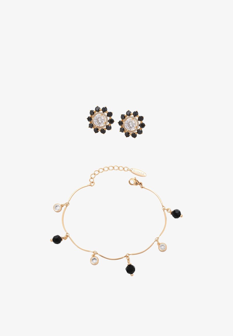 Złota bransoletka z naprzemiennie ułożonymi czarnymi i przezroczystymi okrągłymi zawieszkami, zestawiona ze złotymi kolczykami na sztyft z przezroczystym środkiem otoczonym czarnymi kamieniami.
