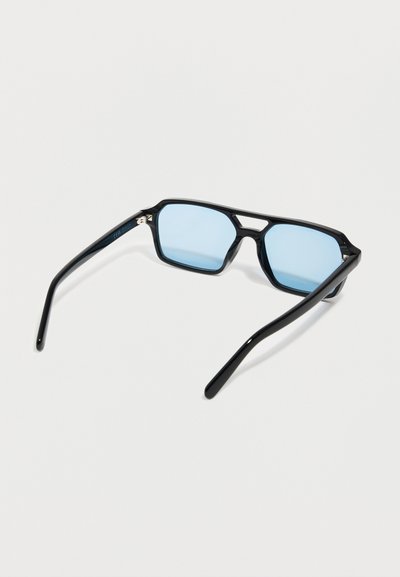 Black rectangular sunglasses with blue tinted lenses resting open on a white surface.