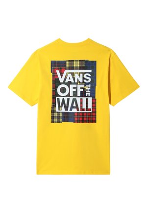 Żółta koszulka z dużą wielokolorową kratkowaną naszywką na plecach, z napisem "Vans Off The Wall" w pogrubionych białych i czarnych literach.