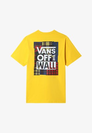 Żółta koszulka z dużą wielokolorową kratkowaną naszywką na plecach, z napisem "Vans Off The Wall" w pogrubionych białych i czarnych literach.