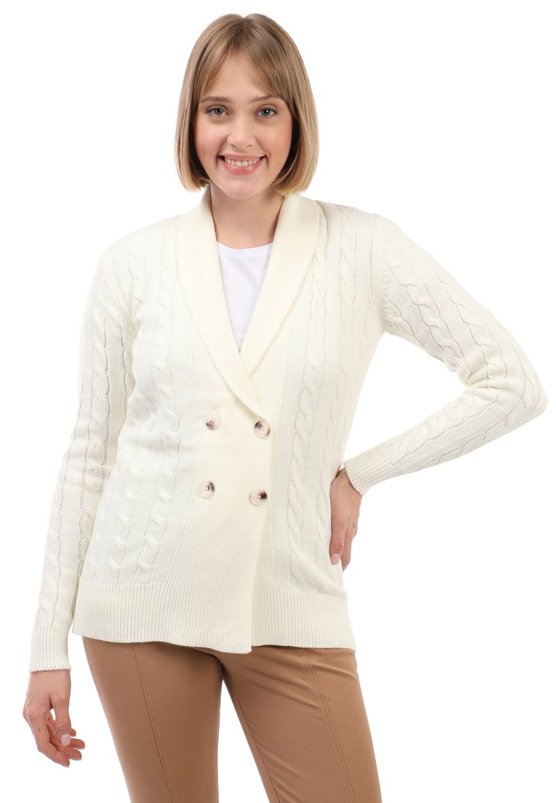 Crème-kleurige kabelgebreide cardigan met een sjawlboord, dubbele knopen en geribde manchetten, gecombineerd met aansluitende tankleurige broek.