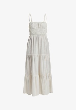 Robe maxi blanche en tissu léger avec un corsage smocké, des fines bretelles et des volants à plusieurs niveaux au bas.