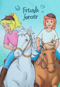 Illustrazione di due ragazze che cavalcano cavalli, uno bianco con una briglia blu e uno marrone con un dettaglio blu, su uno sfondo azzurro chiaro. Testo: "Amiche per sempre."