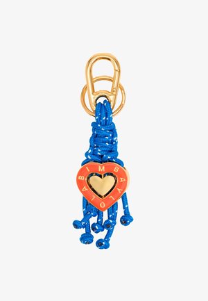 Porte-clé en or avec des glands en corde tressée bleue et un charm en forme de cœur rouge embossé de "LOLA B IMBA" en lettres dorées.
