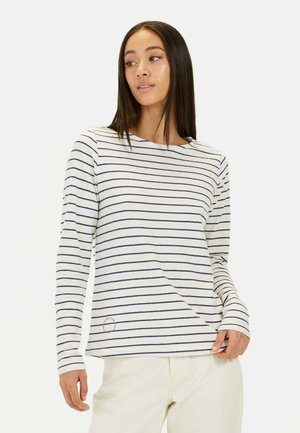 Chemise à manches longues rayée en crème avec des rayures horizontales bleu marine. Elle présente un col rond et des détails brodés près de l'ourlet. Matière en mélange de coton.