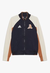 Navy blue zip-up jacket with cream and brown accents, ribbed collar and cuffs, featuring an embroidered letter "A" and an adidas logo.