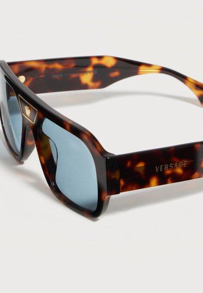 Ορθογώνια γυαλιά ηλίου με ταρταρούγα και μπλε φακούς, χρυσό έμβλημα Versace Medusa στη γωνία και λογότυπο Versace στο μπράτσο.