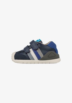 Zapato infantil azul marino con dos correas de Velcro, rayas grises y azules, suela de goma y un acento texturizado en el talón.