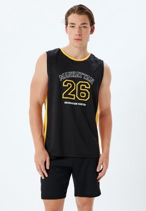Sort ærmeløs sports skjorte med gul kanten, med "MANHATTAN 26 RECREATION CENTER" i fed skrift. Sorte shorts supplerer toppen.