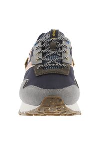 Zapatilla multicolor que presenta una combinación de tela azul marino, ante gris y toques de naranja y amarillo, con cordones texturizados y una suela robusta.