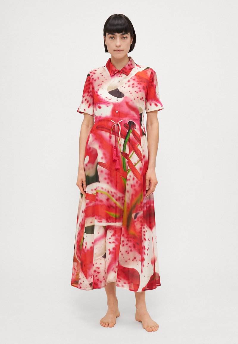 Rochie imprimeu floral în roșu și roz, cu mâneci scurte, față cu nasturi și cordon. Fabricată dintr-un material ușor, are un design fluid.
