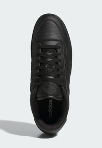 Černé kožené tenisky s perforovanou špičkou, plochými tkaničkami, reliéfním logem a polstrovaným límcem, se strukturální mezipodešví a hladkým povrchem.