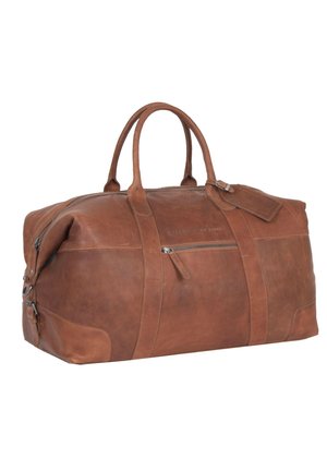 Sac de voyage en cuir marron avec deux poignées, une poche zippée à l'avant et une étiquette de bagage. Présente une texture lisse et une forme arrondie.
