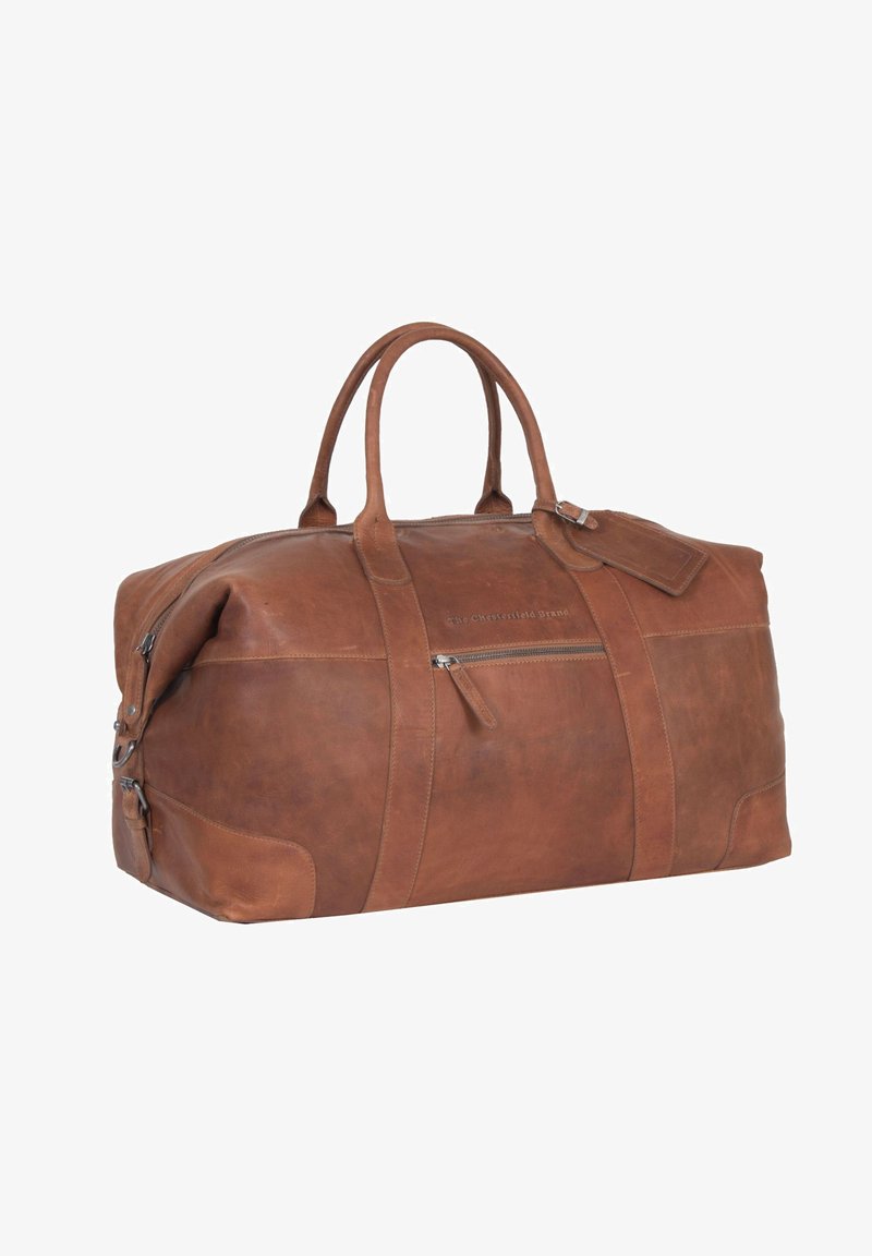 Ruskea nahkainen matkakassi, jossa on kaksinkertaiset kahvat, etupuolella vetoketjullinen tasku ja matkataga. Ominaisuuksiin kuuluu sileä pinta ja pyöreä muoto.