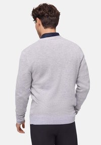 Hellgrauer Strickpullover mit Rundhalsausschnitt, gerippten Bündchen und Saum. Glatte Textur und enganliegendes Design, von hinten betrachtet.