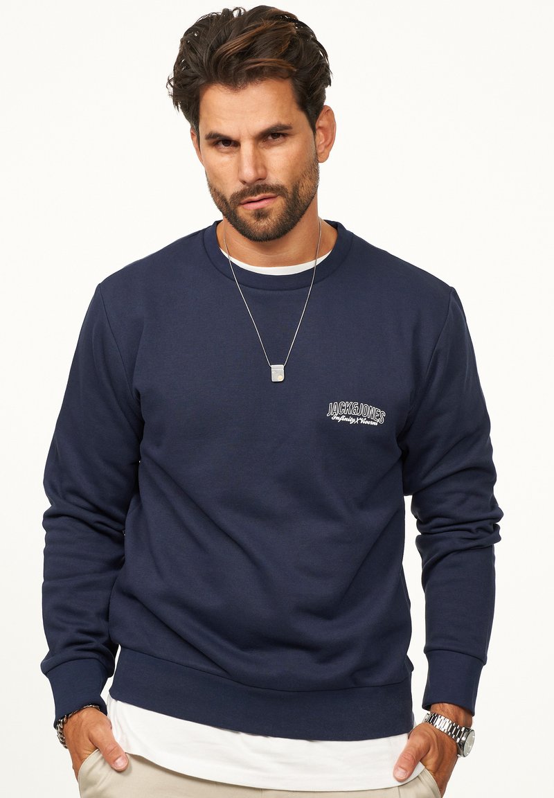 Navy blue crewneck sweatshirt made of soft cotton. Features a small logo on the chest, ribbed cuffs, and a relaxed fit.