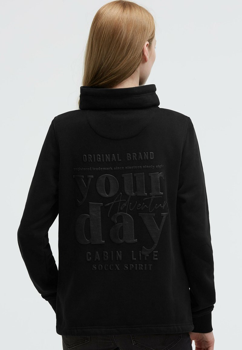 Black hooded sweatshirt with a soft texture, featuring embossed text on the back: "your day Adventure CABIN LIFE SOCcx SPIRIT."