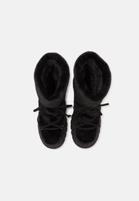 Fekete, prémes bakanccal, puha tapintással, lekerekített felsőrésszel és fűződíszítéssel. A dizájn letisztult talpat és minimalista fém kiegészítőket tartalmaz.