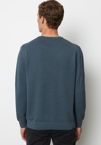 Blauer gestrickter Pullover mit einem strukturierten Muster, Rundhalsausschnitt und langen Ärmeln, mit gerippten Bündchen und Saum, von hinten gezeigt.