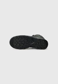 Suola di scarpe da trekking nera con un motivo di battistrada profondo e robusto per una maggiore aderenza. Presenta il marchio Lowa e una superficie liscia con area della punta rinforzata.