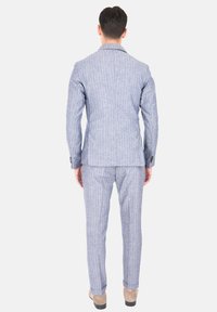 Completo a righe blu chiaro con vestibilità strutturata, dotato di rever a punta, due sventagli posteriori e pantaloni abbinati con profilo slim.