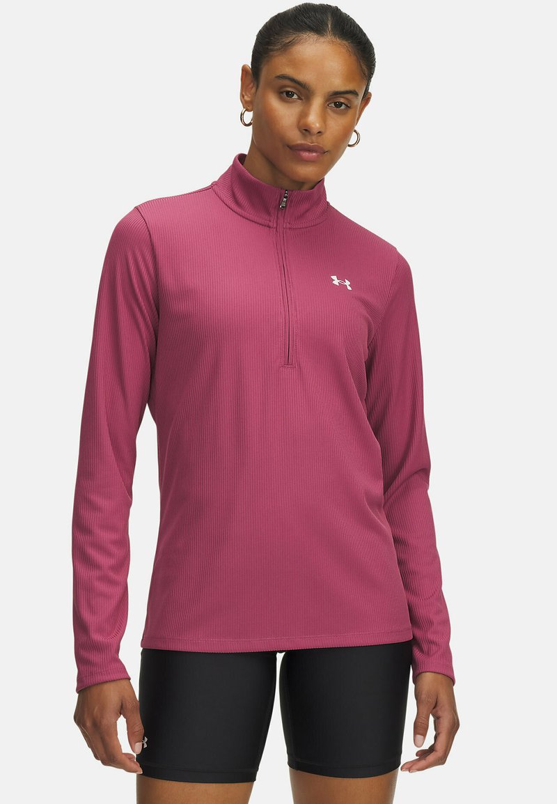 Fuchsia long-sleeve athletic top with a quarter-zip collar, ribbed texture, and white logo on the left chest, paired with black shorts.