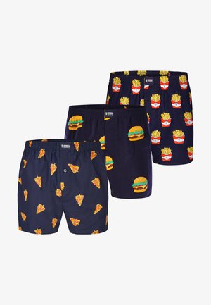 Tre par mørkeblå boxershorts med gentagne tryk af pizzastykker, hamburgere og røde beholdere med pommes frites.