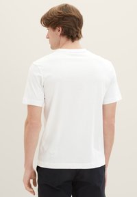 Weiße Baumwoll-T-Shirt mit kurzen Ärmeln, rundem Halsausschnitt und glatter Textur. Die Rückansicht zeigt ein schlichtes Design ohne Muster oder Akzente.