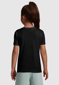 Sort t-shirt med korte ærmer og rund halsudskæring, glat tekstur og et simpelt design, iført med lysegrønne shorts.
