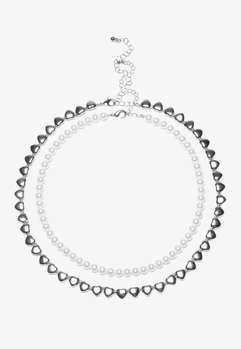 Zweischichtiges Halsband mit silbernen herzförmigen Perlen und weißen Perlen. Verstellbarer Kettenverschluss für einen sicheren Sitz. Glatte Textur und glänzende Oberfläche.