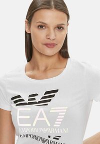 T-shirt bianco a maniche corte con scollatura rotonda e design del logo multicolore. Tessuto morbido con una finitura liscia e vestibilità slim.