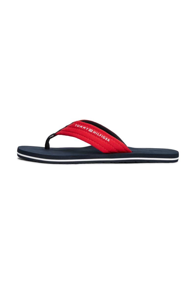 Tongs rouges et noires avec des brides texturées et une semelle rembourrée marine ; présentent un logo blanc et un bord rayé en bas.