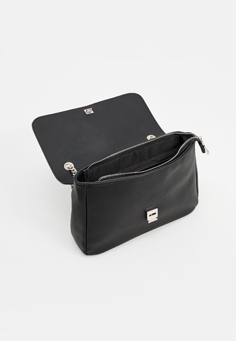 Borsa a tracolla in pelle nera con chiusura a zip, accessori in argento e un compartimento aperto. Texture liscia e design minimalista.