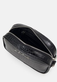 Svart kosmetikaväska i läder med krokodilmönster, dragkedja, ett fack och detaljer i silverton med varumärkesprofil.