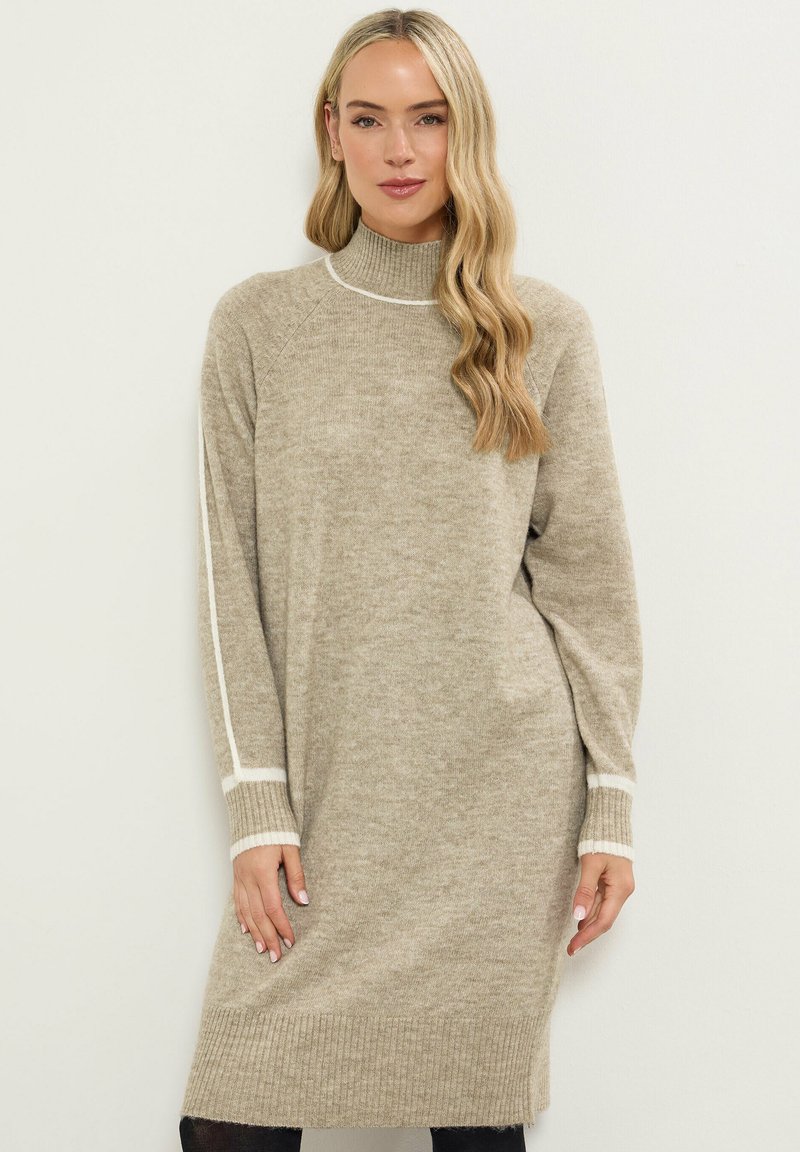 Abito maglione beige con collo alto, maniche lunghe e righe bianche sulle braccia. L'orlo e i polsini a costine aggiungono texture.