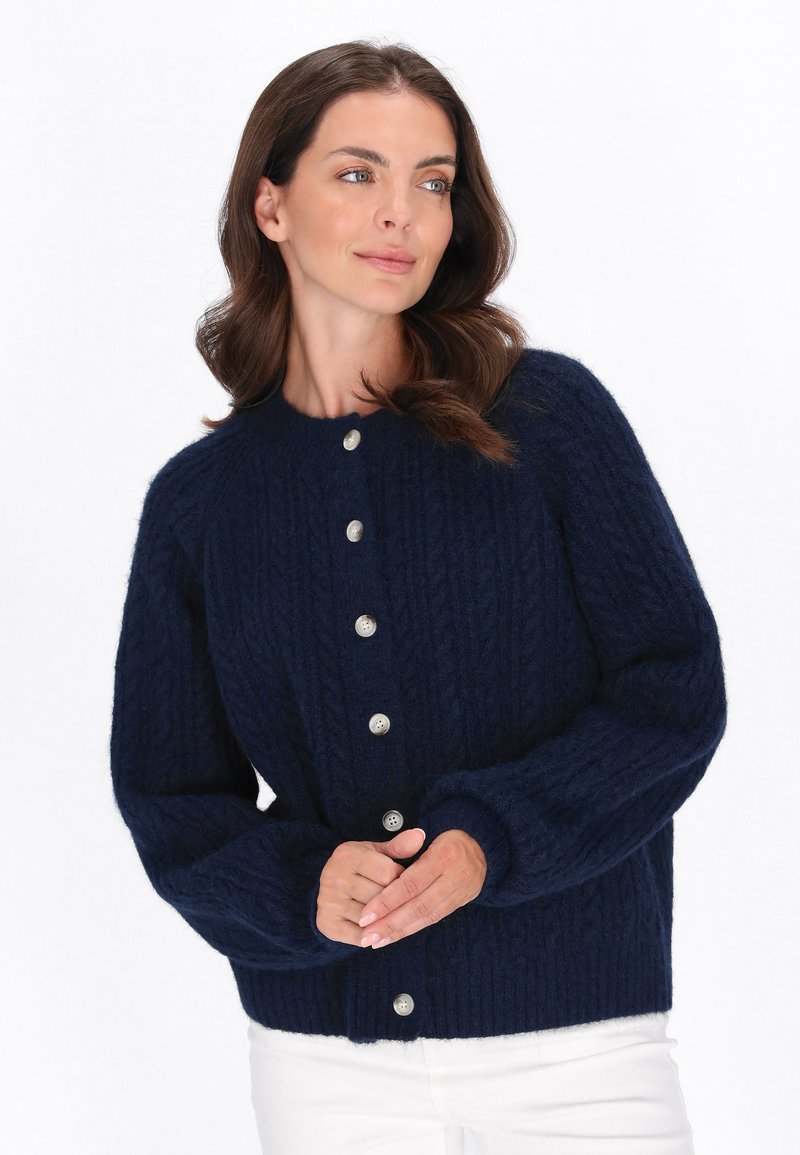 Cardigan di colore blu navy, con texture, colletto rotondo e chiusura a bottoni. Presenta polsini e orlo a coste, realizzato in un morbido materiale a maglia.