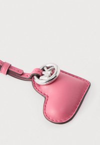 Μπρελόκ καρδιά σε σχήμα από ροζ δέρμα με ασημένιο μεταλλικό κρίκο. Διαθέτει αντίθετη ραφή και λεία υφή.