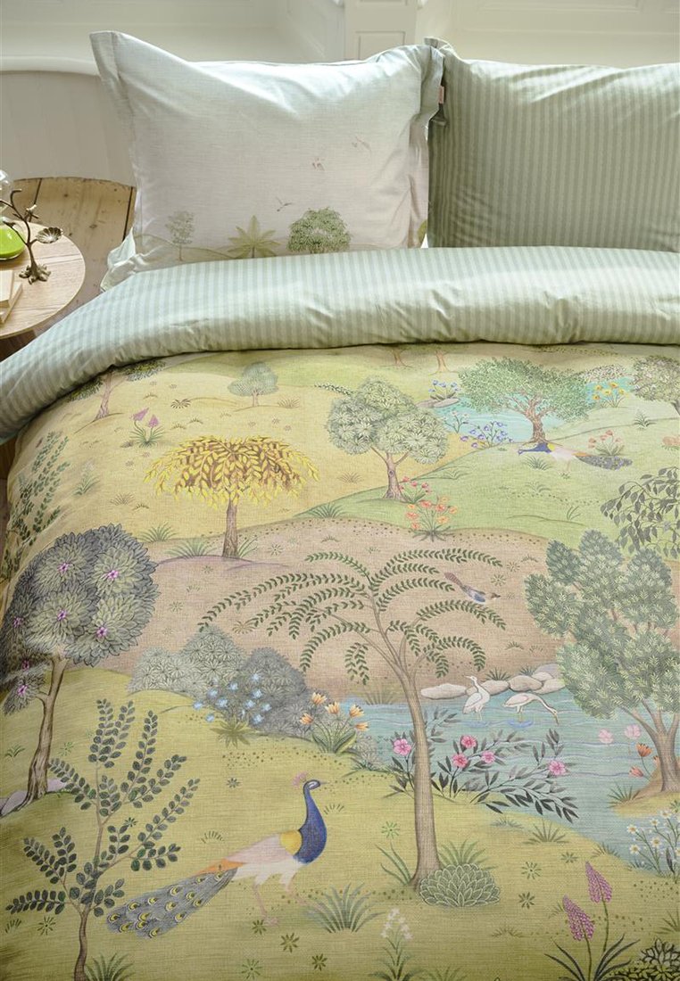 Zestaw pościeli pikowanej z zieloną poszewką na poduszkę, z kolorowym nadrukiem krajobrazu przedstawiającym drzewa, kwiaty i wzór z pawiem.