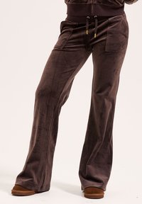 Bruine velours broek met een uitlopende vorm, voorzien van twee voorzakken, een trekkoord in de taille en een zachte, gladde textuur.