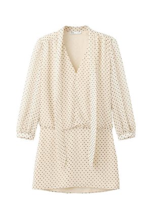 Vestido de manga larga color crema con pequeños lunares negros, escote en V, lazo en la cintura y mangas ligeramente abullonadas.