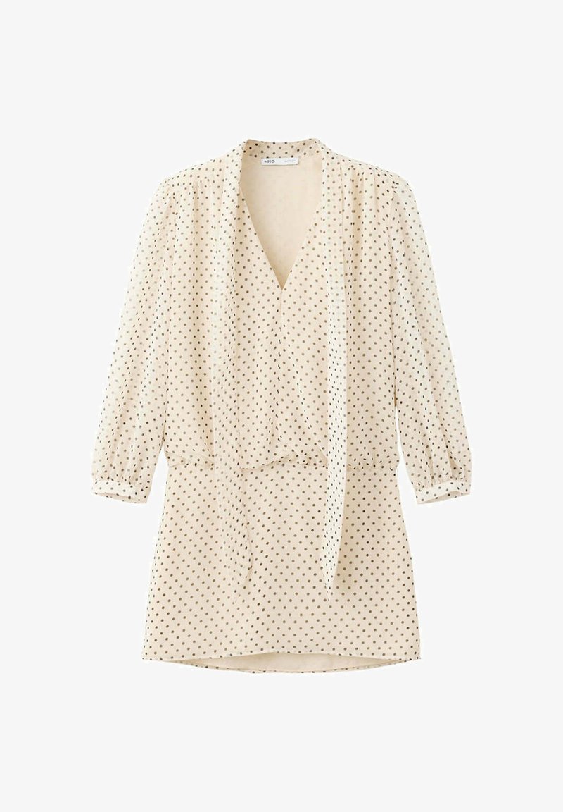 Robe longue à manches longues de couleur crème avec petits pois noirs, col en V, ceinture à la taille et manches légèrement bouffantes.