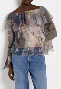 Sheer, floral-patterned blouse with ruffled layers, off-shoulder design, and long sleeves; multi-colored with pastel hues; soft texture.