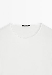 Hvid bomulds t-shirt med rund halsudskæring og blød tekstur. Sort label i nakken læser "Massimo Dutti, MADE IN PORTUGAL."