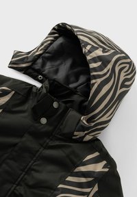 Schwarze Jacke mit einer beigen, zebra gestreiften Kapuze. Hergestellt aus glattem Material, verfügt sie über Druckknöpfe und ein elegantes Design.