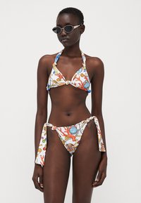 Bikini sett i hvitt stoff med fargerikt maritimt trykk. Har trekantet topp, sideknyting i bunnen og knute-detaljer.