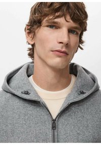 Szara bluza z polaru na zamek z kapturem ze sznurkiem, charakteryzująca się gładką fakturą, precyzyjnym szyciem i subtelnymi metalowymi detalami.