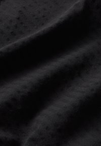 Schwarzer Stoff mit einer glatten Textur und dezentem Fischgrätenmuster in verschiedenen Schwarznuancen. Reiche, weiche Ausstrahlung.
