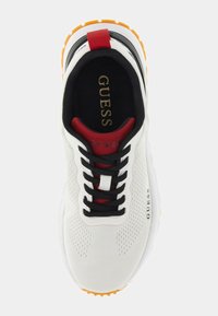 Chaussure de sport blanche avec tige en mesh, lacets noirs, accents rouges sur la languette et semelle orange. Présente un logo en relief sur le côté.