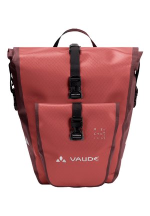 Rode waterdichte rugzak met een textured oppervlak, twee voorste gespen, een handvat aan de bovenkant en een rechthoekige vorm. Bevat een label van gerecycled materiaal.