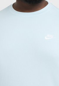 Felpa Nike azzurro chiaro con collo rotondo, morbida al tatto e con un piccolo logo bianco nella zona sinistra del petto.